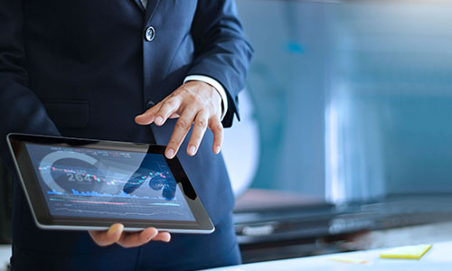 A man in a suit shows some financial data on a tablet